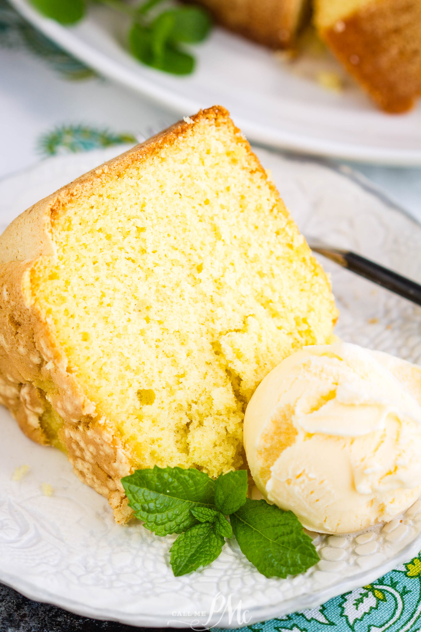 A great use of leftover egg yolks, Twelve Yolk Pound Cake, is golden and soft. A great basic cake that's not overly sweet. Serve this with a good vanilla ice cream and rich caramel sauce. Twelve Yolk Pound Cake is versatile, buttery, and delicious. A slice of rich Twelve Yolk Cake on a white plate, served with a scoop of vanilla ice cream and garnished with fresh mint leaves.