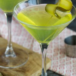 Dill pickle martini in martini glass with cucumber garnish.