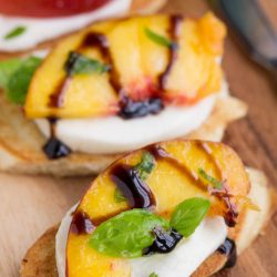Appetizer. Sweet summer peaches are served on a toasted French baguette and a pillow of mozzarella cheese