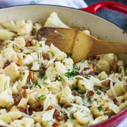 Sautéed Cauliflower and bacon oven baked in a cheesy creamy garlic sauce topped with bubbling mozzarella and parmesan cheese!