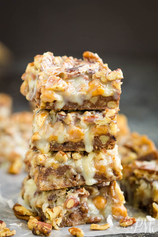 A stack of Pecan Pie Magic Cookie Bars on top of a piece of parchment paper.