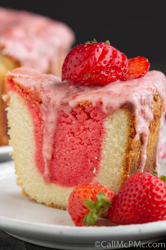 A slice of strawberry pound cake on a plate with a dollop of cream.