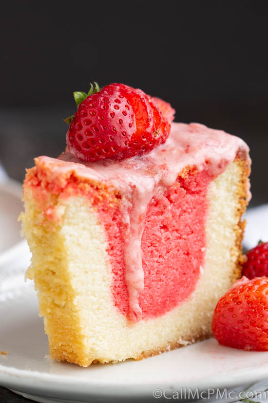 Strawberry & Cream Pound Cake with Jello is a super moist pound cake with two very special flavors. The favorite combination of strawberries and cream is put together in a unique way to make an extraordinary pound cake! A slice of strawberry cream pound cake on a plate.