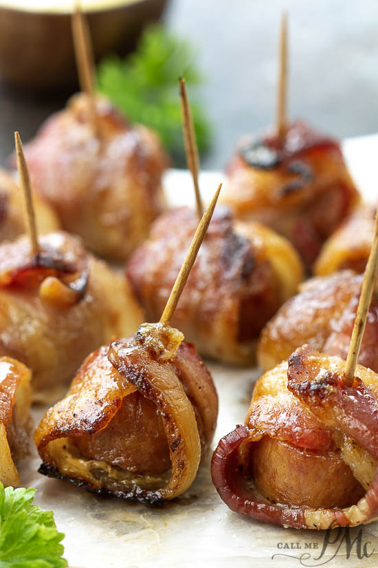skewers of sausage appetizers wrapped with bacon.