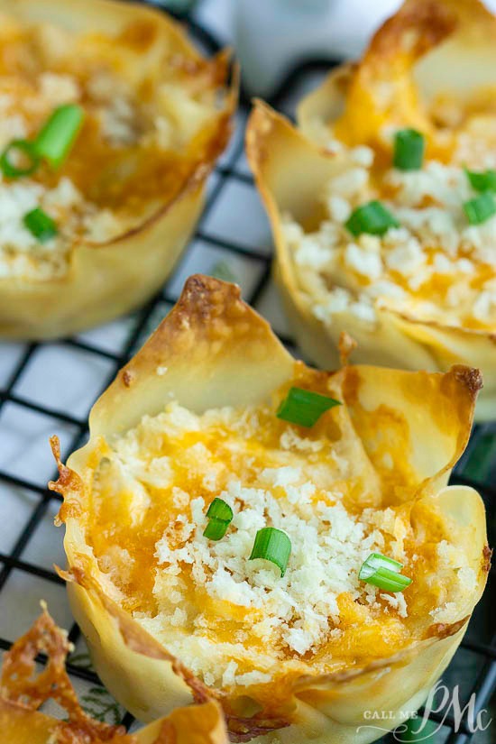 Easy and hearty, Crack Wontons are a two-bite appetizer that's filled with creamy, flavorful Crack Chicken. #chicken #appetizer #bacon A close-up of crispy Crack Wontons, their cheese-filled centers crowned with chopped green onions, resting invitingly on a cooling rack.