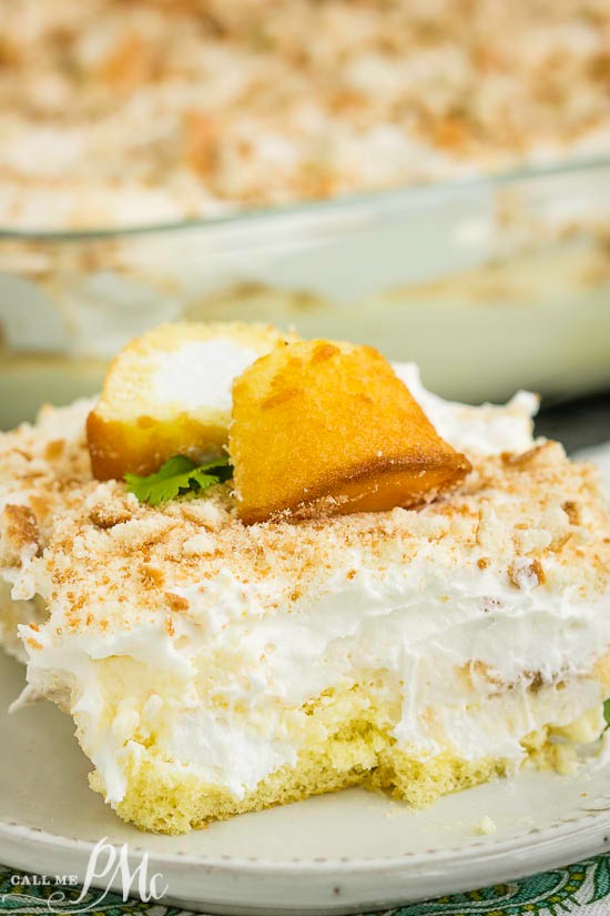No Bake Banana Pudding Twinkie Cake has an incredible cream cheese pudding filling, lots of bananas, & is served over delicious Twinkie snack cakes! Close-up of cake. It's garnished with two small cake squares on a white plate.