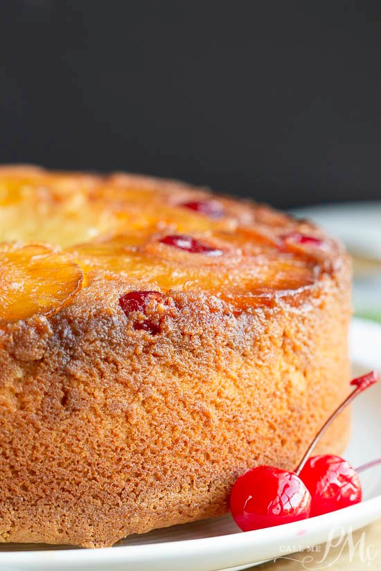 Side view of beautiful tube pan baked cake with cherry garnish.