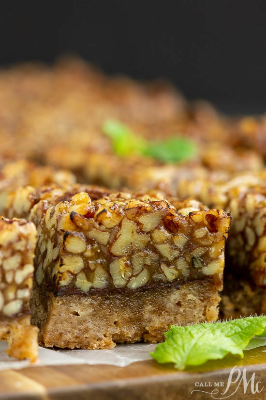 Pistachio bars on a cutting board with mint leaves.