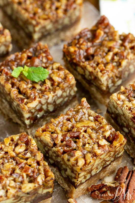 Enjoy these Mexican style Pecan Chocolate Squares that are packed with pecans. They're easy to make, easy to transport, and great for year around noshing. #PecanPie #bars #chocolate Pecan bars on a baking sheet with a mint sprig.