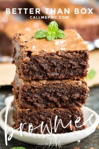 Three stacked brownies with a mint leaf on top are displayed on a small plate, surrounded by more delectable treats in the background. Text overlay reads "Better Than Box" and "callmepmc.com.