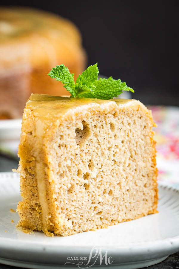 This delicious Cinnamon Crack Cake Recipe is spiced with cinnamon and topped with a rich butter sauce. #cake #bundtcake #dessert #cinnamon #recipes Slice of dessert on a plate with mint leaves on top.