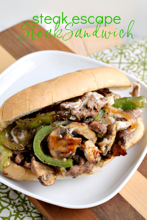 This Grand Escape Steak Sandwich has thinly sliced beef is cooked to perfection, melty cheese, peppers, onions, seasonings, and sauces. #steak #sandwich #recipe #beef #phillycheesesteak #cheesy Steak Escape Steak Sandwich