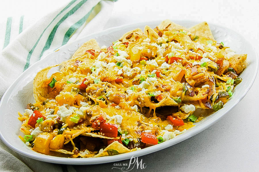chips with cheese Tortilla chips on a platter with fish, peppers, and cheese.