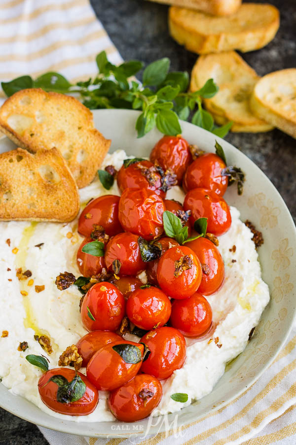Olive oil over cheese spread and thyme garlic roasted tomatoes Whipped Feta with Blistered Tomatoes