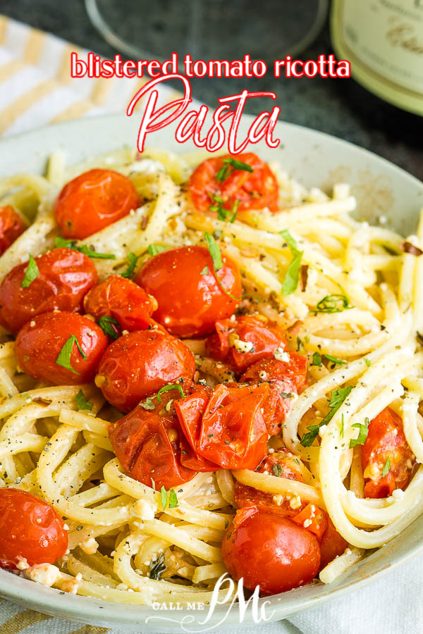 A plate of blistered tomato ricotta pasta, tossed with cherry tomatoes and herbs, garnished with black pepper.