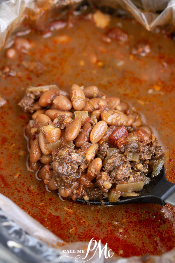 beans and sausage in a slow cooker beans in a pot in a ladle