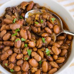 Slow Cooker Pinto Beans and Sausage are simple to make with incredible flavor. These beans slow-cooked all day for some delicious comfort food.