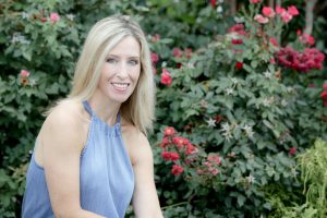 lady sitting with flowers behind her