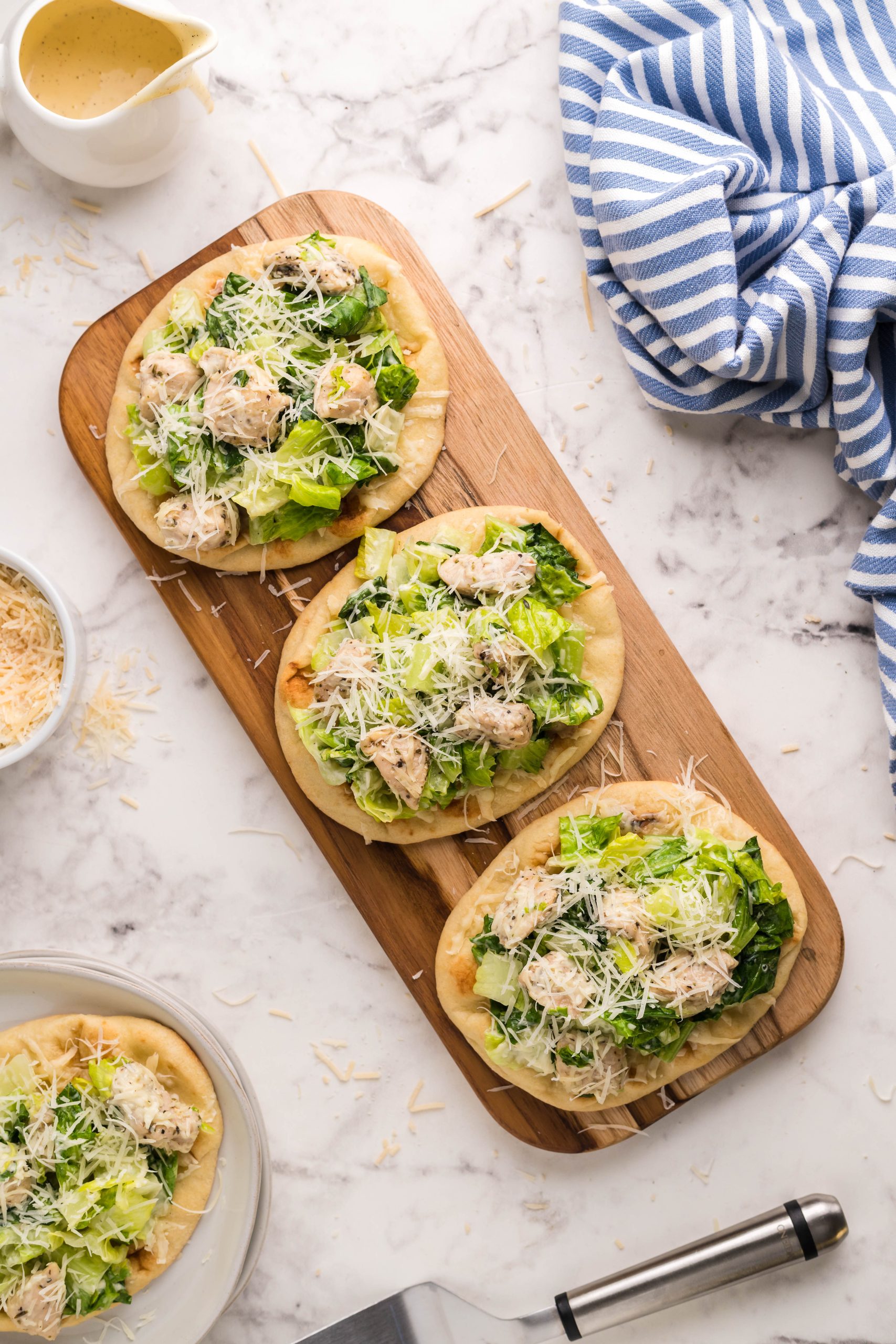 20 Minute Chicken Caesar Flatbread is quick, easy, and totally satisfying. This recipe is super quick to pull together using store-bought flatbread, seasoned pan sauteed chicken, and your favorite Caesar salad dressing.
