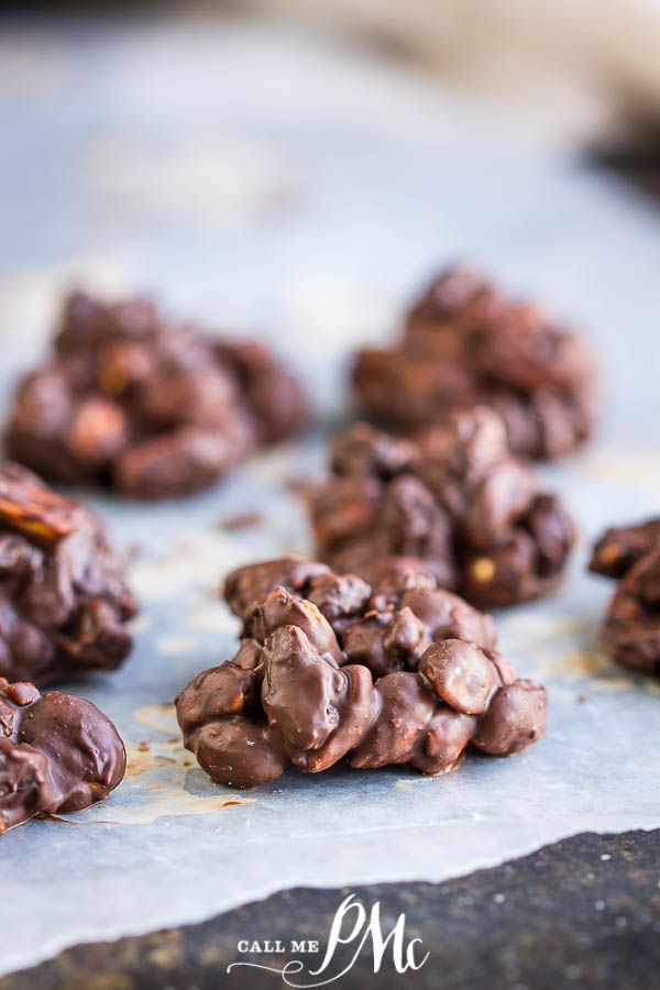 Chocolate peanut and dried cranberry clusters on a baking sheet.