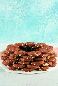 stacking red velvet cookies on a platter.