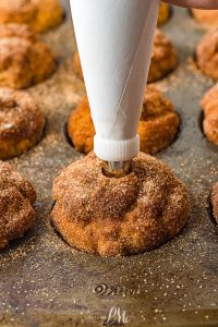 filling a muffin with dulce de leche.