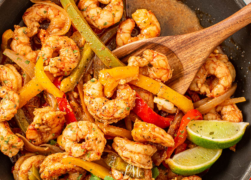 shrimp and peppers in pan Shrimp and peppers in a skillet with serving spoon.