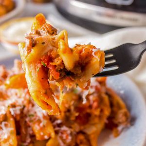 Slow Cooker Cheesy Penne by Call Me PMc in a rich beefy tomato sauce is full of ground beef, tomato sauce, pasta, and cheese. It's an easy Crock Pot comfort food recipe the whole family loves.