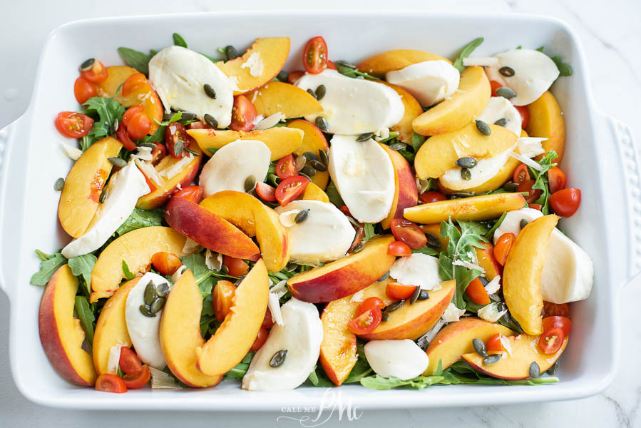 peach salad Sliced peaches, tomatoes, and fresh mozzarella slices on a tray.