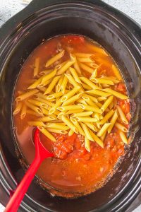 A Slow Cooker Cheesy Penne simmering in tomato sauce.