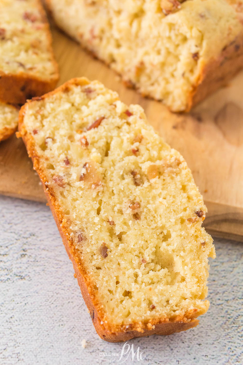 A quick bread with pecans on a cutting board.