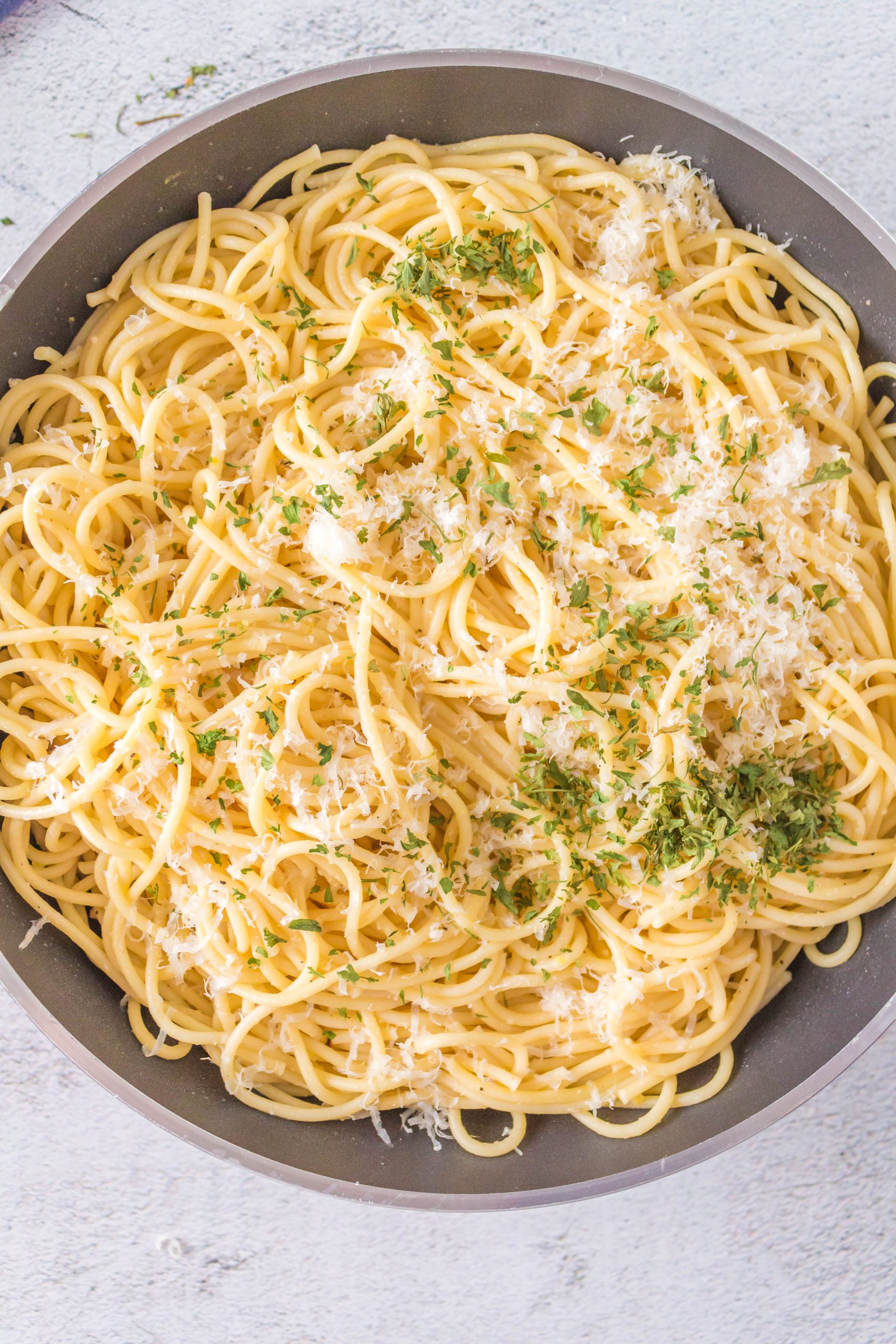A fast and easy bowl of spaghetti with parmesan cheese and parsley.