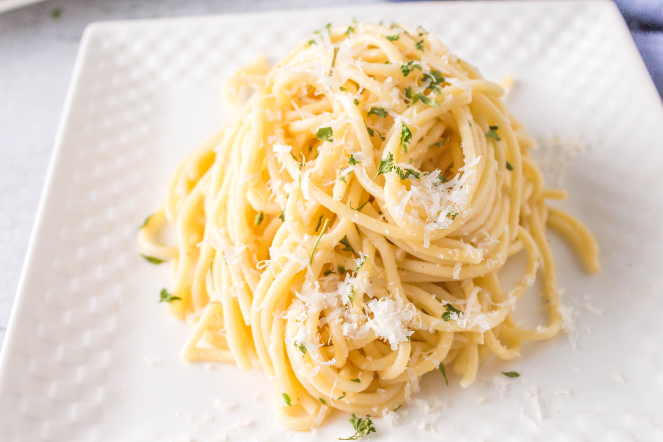A fast and easy plate of pasta with parmesan cheese and parsley.