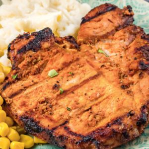Juicy Marinated Grilled Pork Chops are coated in a simple and tasty homemade spice rub then deliciously seared to seal in the flavor and juices. #porkchops #grilling.