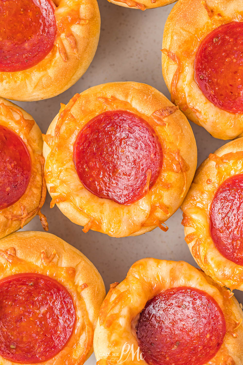 A muffin pan filled with pepperoni pizza bites is displayed on a table.