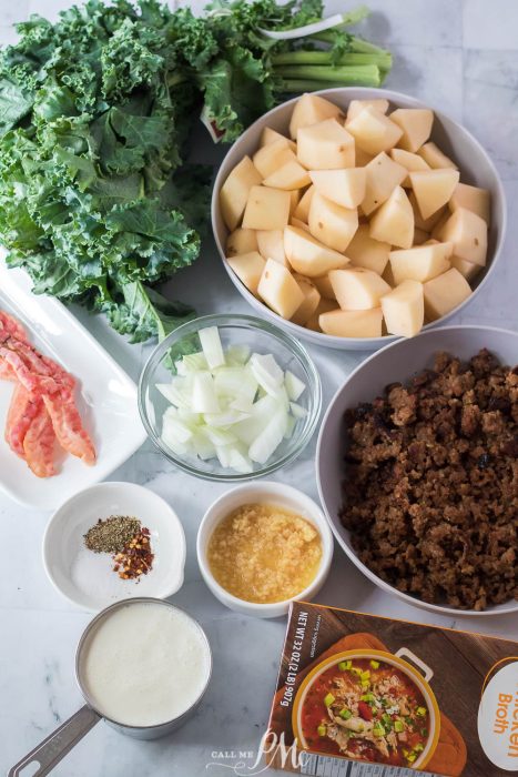 The ingredients for a Slow Cooker Zuppa Toscana soup are laid out on a table.