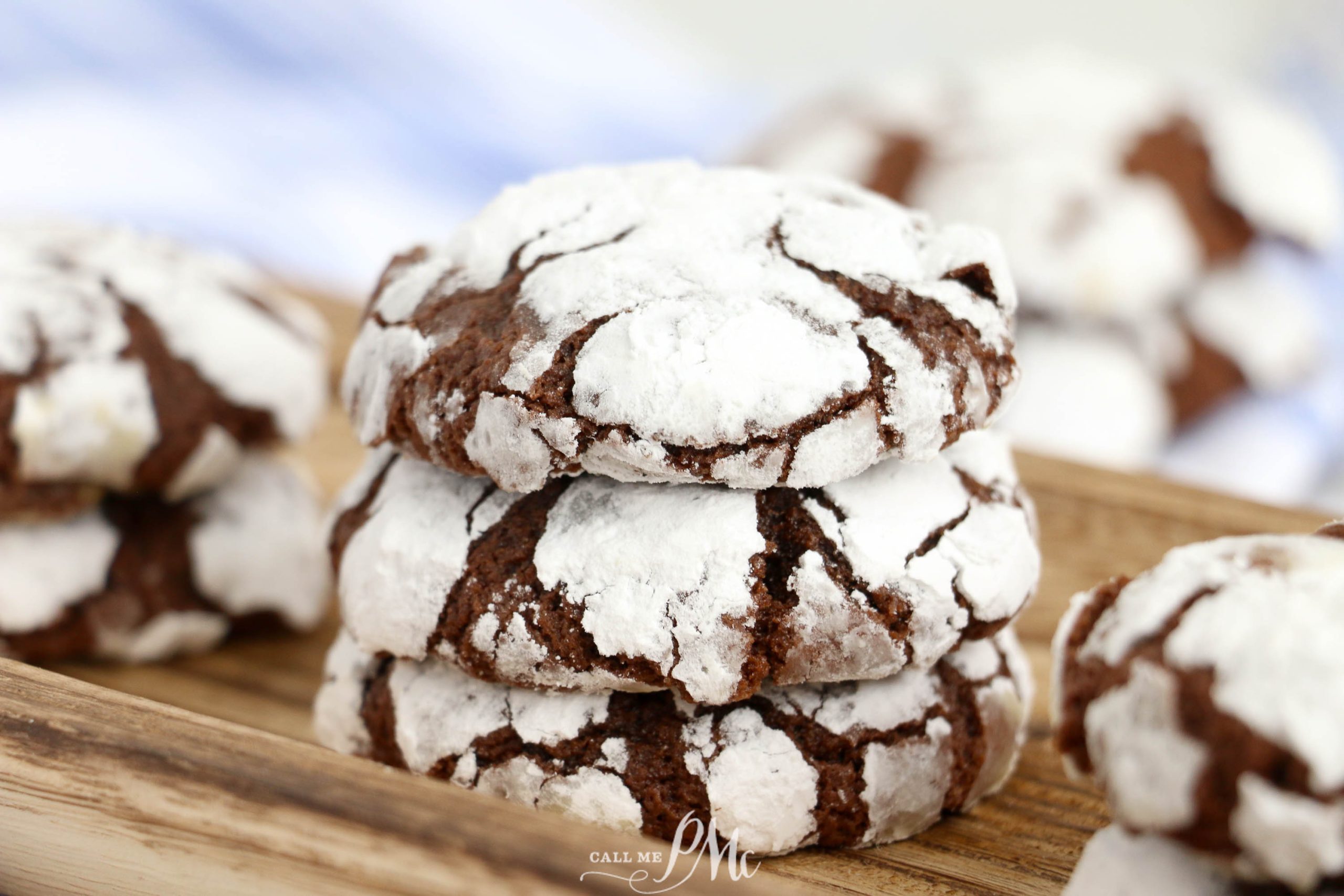 Stack of chocolate crinkle cookies on a board.