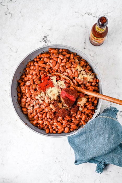 mixing together baked beans in bowl