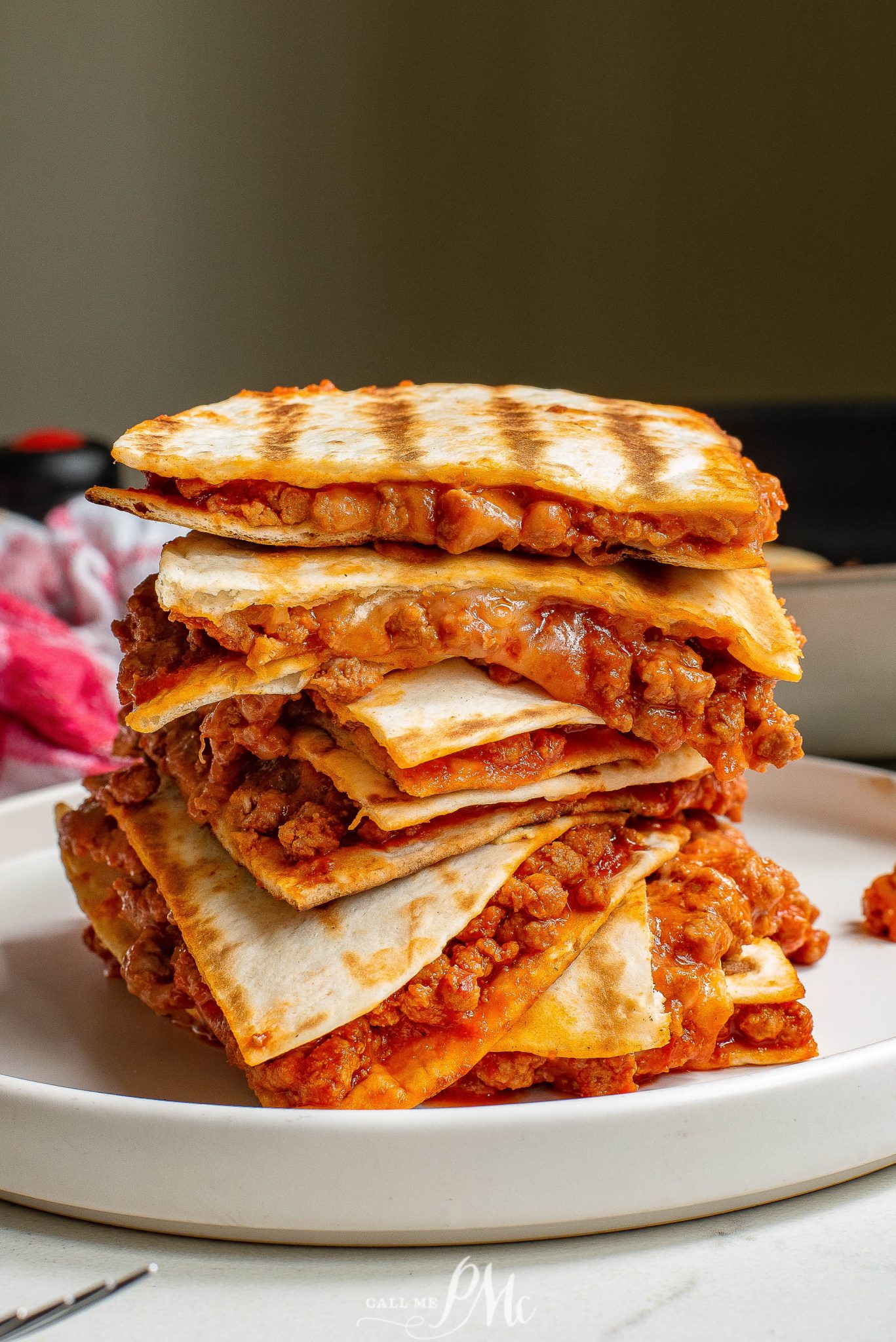 Stack of sloppy Joe quesadillas, packed with juicy meat and melted cheese, sizzling on a grill pan.