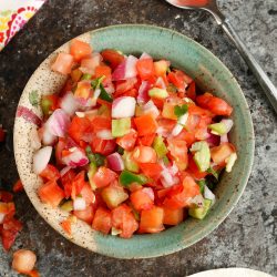 Chopped tomatoes, onion, and jalapeon in a bowl.