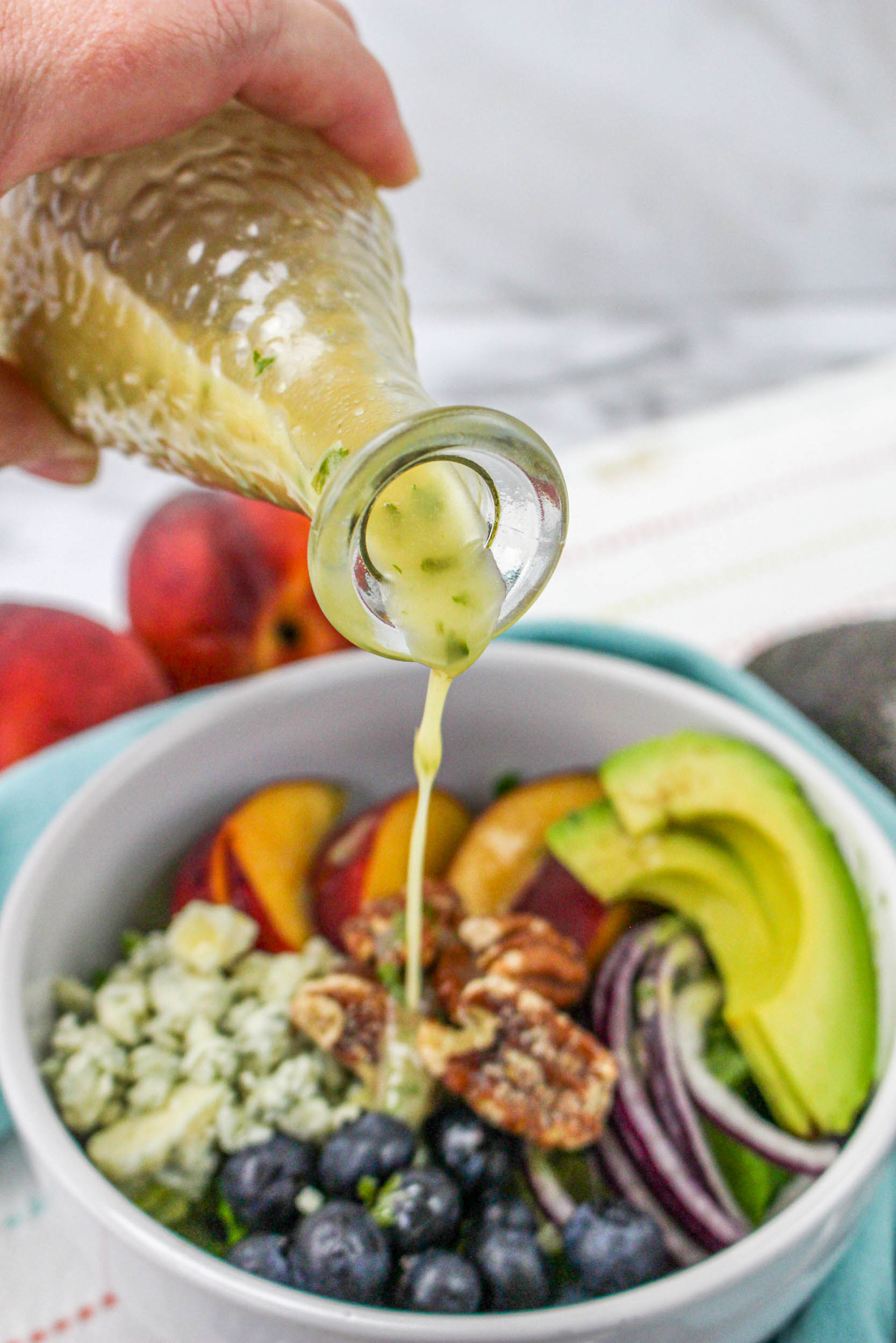 Fresh salad dressing beinf poured out of jar onto a steak.