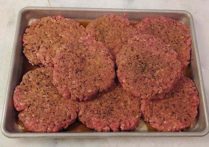 Tray of raw hamburger on a table.