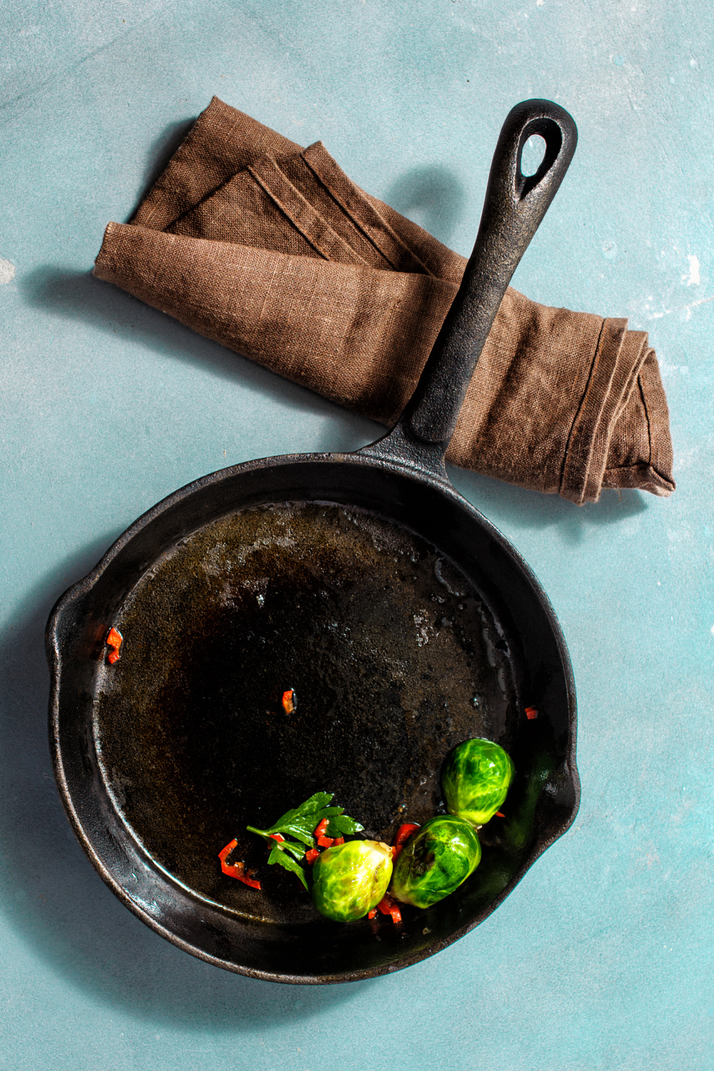 Flatlay of cast iron skillet with a little food in it.