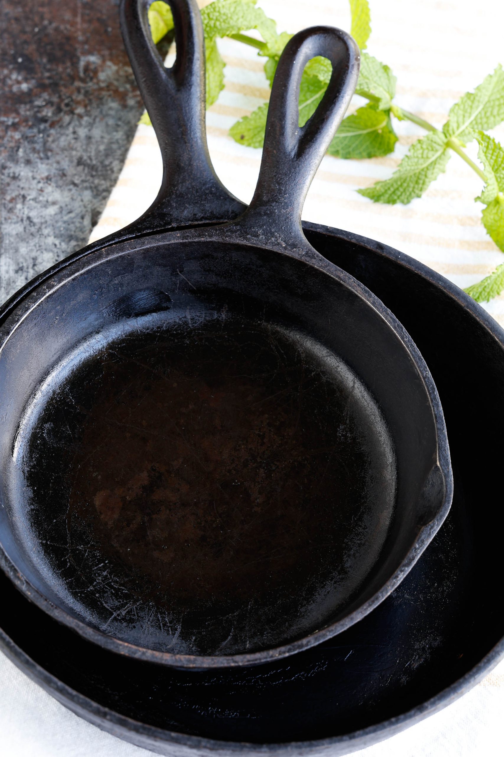 Two seasoned cast iron skillets.