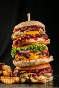 Stack of three cooked and dressed hamburgers
