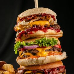 Stack of three cooked and dressed hamburgers