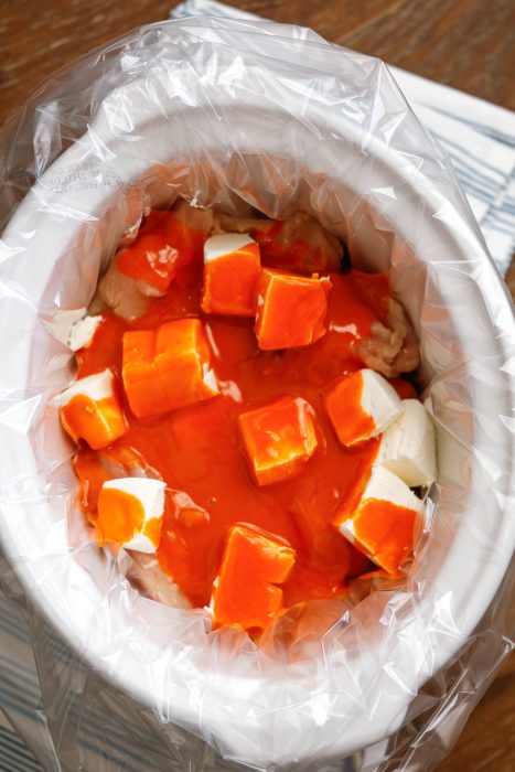 Chicken, cream cheese, and buffalo sauce in crock pot.