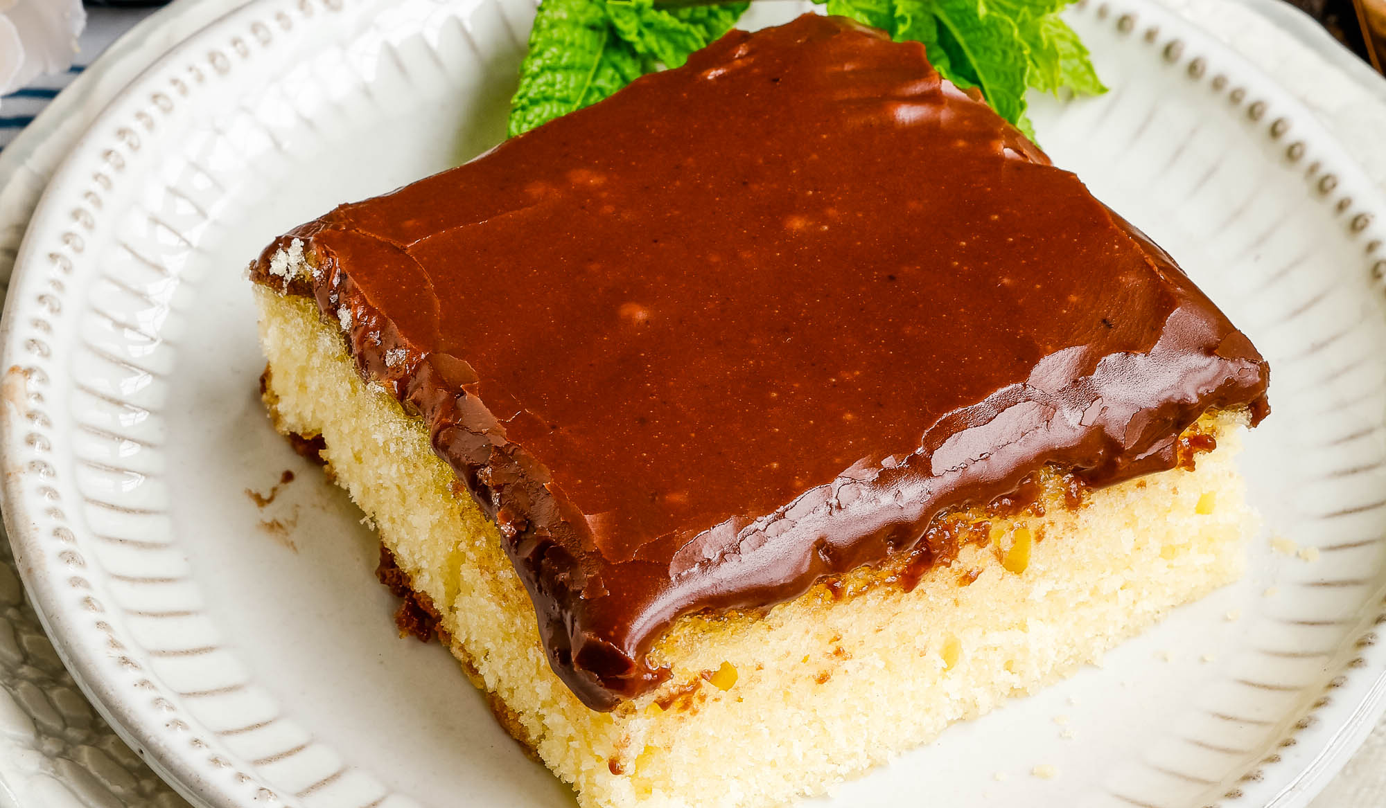 Flat lay of square hot milk cake on plate.