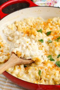 Large pan with pasta and cheese and serving spoon