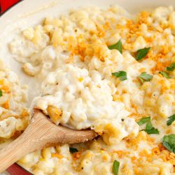 Large pan with pasta and cheese and serving spoon